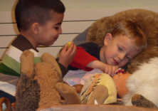 Zwei kleine Jungs versorgen eine Babypuppe