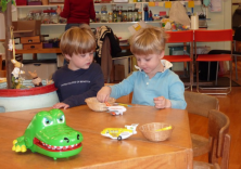 Zwei kleine Jungs am Tisch mit Spielflugzeugen und Krokodil