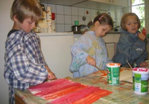 Drei Kinder beim Bildermalen in der Küche